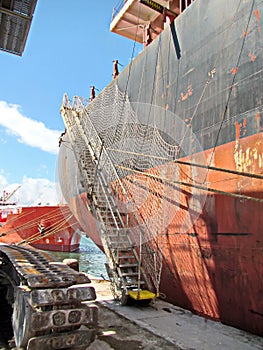 Loading cargo of cement clinker in bulk carrier by ships cranes in the port of Izmir, Turkey.