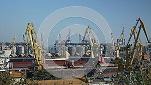 Loading of cargo container into merchant ship. Import export port with many stacks of cargo container rows and big cranes. Logisti