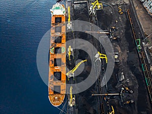 Loading coal Anthracite on bulk vessel ship in offshore cargo port. Aerial top view