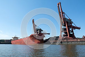Loading coal on an old transport ship in the port