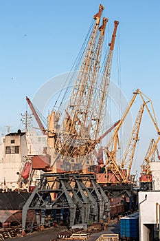 Loading containers on a container ships, port cranes and huge ships bottom up view. port container terminal. Container Ship