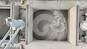 Loading dry cargo ship of sunflowers by cranes in port. Aerial view loading into holds of sea cargo vessel