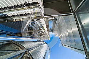 Loading facility building exterior. Low angle view of the tanks and agricultural silos of grain elevator storage