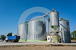 Loading grain by trucks onto the elevator into metal containers