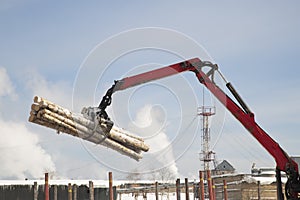 Loading logs on a logging truck. Wood loader. Woodworking industry