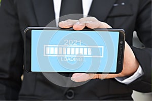 Loading new year 2021. Businessman holding mobile phone with progress bar