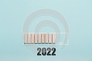 Loading new year 2022 concept , Showing loading bar with wood cube on bluebackground