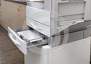 Loading paper tray of the photocopier at the office with full access control for key card.