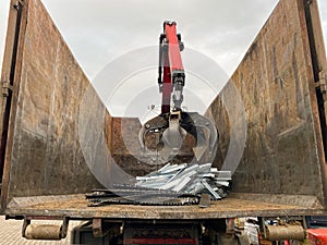 Loading scrap metal into a truck. Crane grabber loading metal rusty scrap in the dock