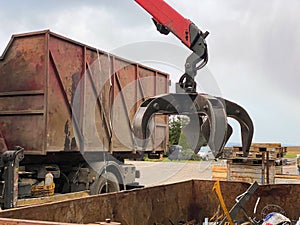 Loading scrap metal into a truck. Crane grabber loading metal rusty scrap in the dock