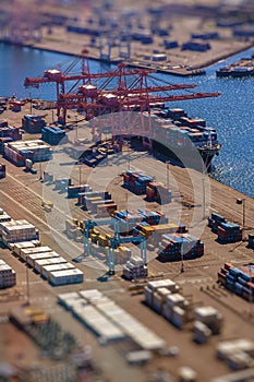 Loading a transport ship with cargo, containers, with tilt-shift lens effect