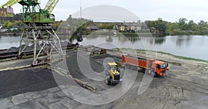 Loading a truck in the port, the excavator loads into the material in the truck