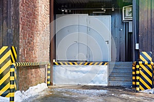 loading and unloading area is the supermarket`s landing stage. A large gray gate and a black-and-yellow fence