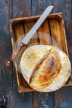 Loaf of artisanal sourdough bread and a knife.