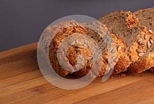 Loaf of bread, cut into slices, lies on a cutting board