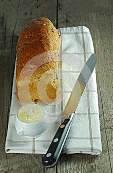 Loaf of bread with knife and butter