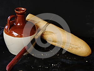 Una barra de pan de pan un cuchillo transición eso próximo sobre el una botella 