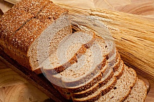 A loaf of bread and shock of wheat on wood photo