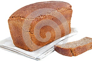 Loaf of bread and slice on doily isolated on white