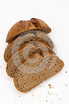 Loaf bread with slices bread on white background, top view