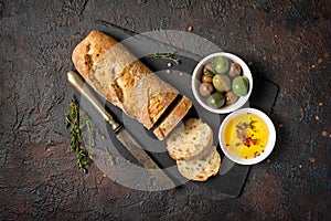 Loaf of bread with spicy olive oil and old rusty table-knife