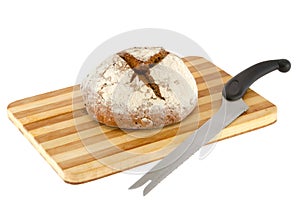 Loaf of bread on a wooden board and knife