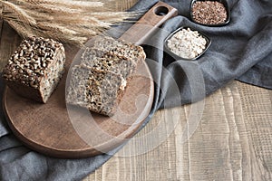 A loaf of fresh rustic rye bread on wooden board. Healphy food background. Close up. Copy space. Fitness wholegrain photo