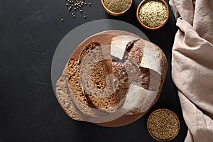 Loaf of freshly baked bread with hemp flour on black.