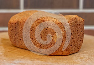 Loaf of homemade freshly baked bread on brown brick wall background