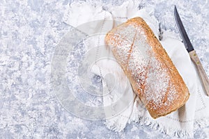 Loaf of homemade no knead sandwich bread with knife, horizontal, top view copy space