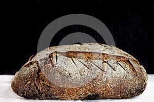Loaf or miche of French sourdough, called as well as Pain de campagne, on display on a black and white background.