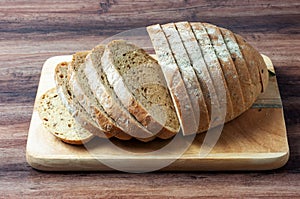 Loaf of multigrain bread on a wood tray photo