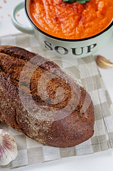 Loaf of rye bread and garlic on linen napkin.