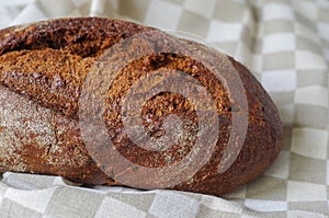 Loaf of rye bread on linen napkin.Selective focus.