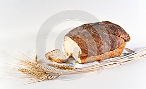 Loaf and slice of wheat bread with wheatears