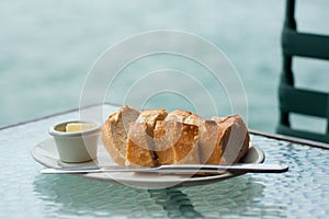 Loaf of sourdough bread with butter on glass table