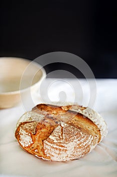 Loaf of sourdough bread, scored and freshly baked in oven