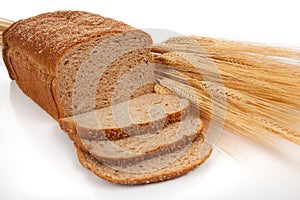 Loaf of wheat bread and shocks of wheat