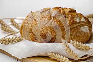 Loaf of wheat bread on towel selective focus