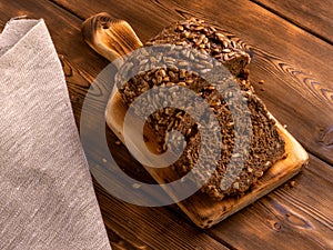 Loaf of whole grain bread on wooden background