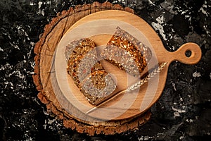 Loaf of wholegrain bread and slices on wooden cutting board. Healthy food. Whole grain rye bread with seeds. Ketogenic low carbs