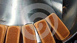 Loafs of bread in a bakery on an automated conveyor belt