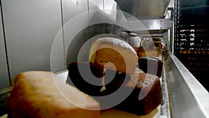 Loafs of bread in a bakery on an automated conveyor belt