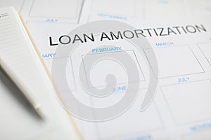 Loan amortization paper plan lying at worktable ready to be filled