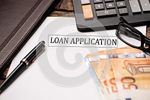 Loan Application text on Document and gavel isolated on wooden office desk photo