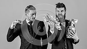 Loan and banking concept. Men in suit, businessmen with jar full of cash and credit card, pink background. Mature man on