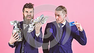 Loan and banking concept. Men in suit, businessmen with jar full of cash and credit card, pink background. Mature man on