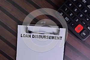 Loan Disbursement write on a paperwork isolated on Wooden Table