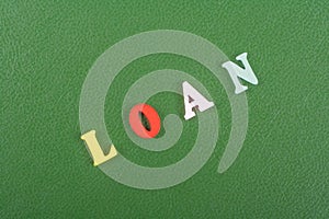 LOAN word on green background composed from colorful abc alphabet block wooden letters, copy space for ad text. Learning english