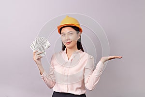 Loans for real estate concept, woman with yellow helmet holding banknote money in right hand and open the empty palm